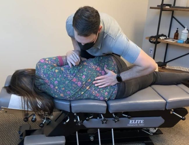 chiropractor performing a low back adjustment
